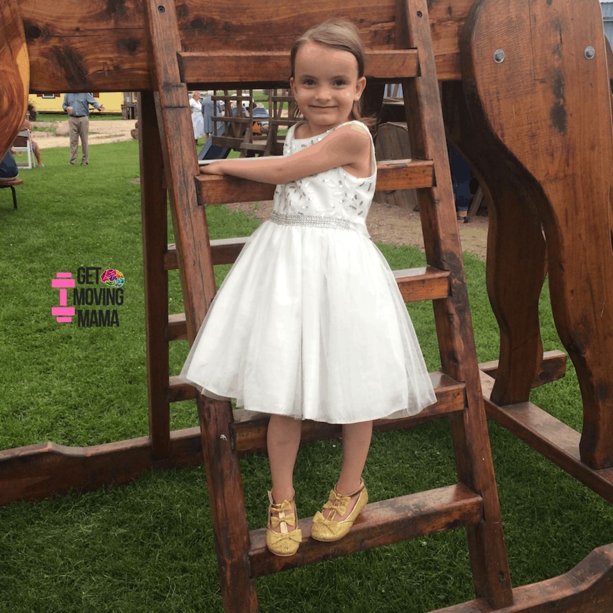 A young girl climbing a ladder to get on a giant rocking horse.