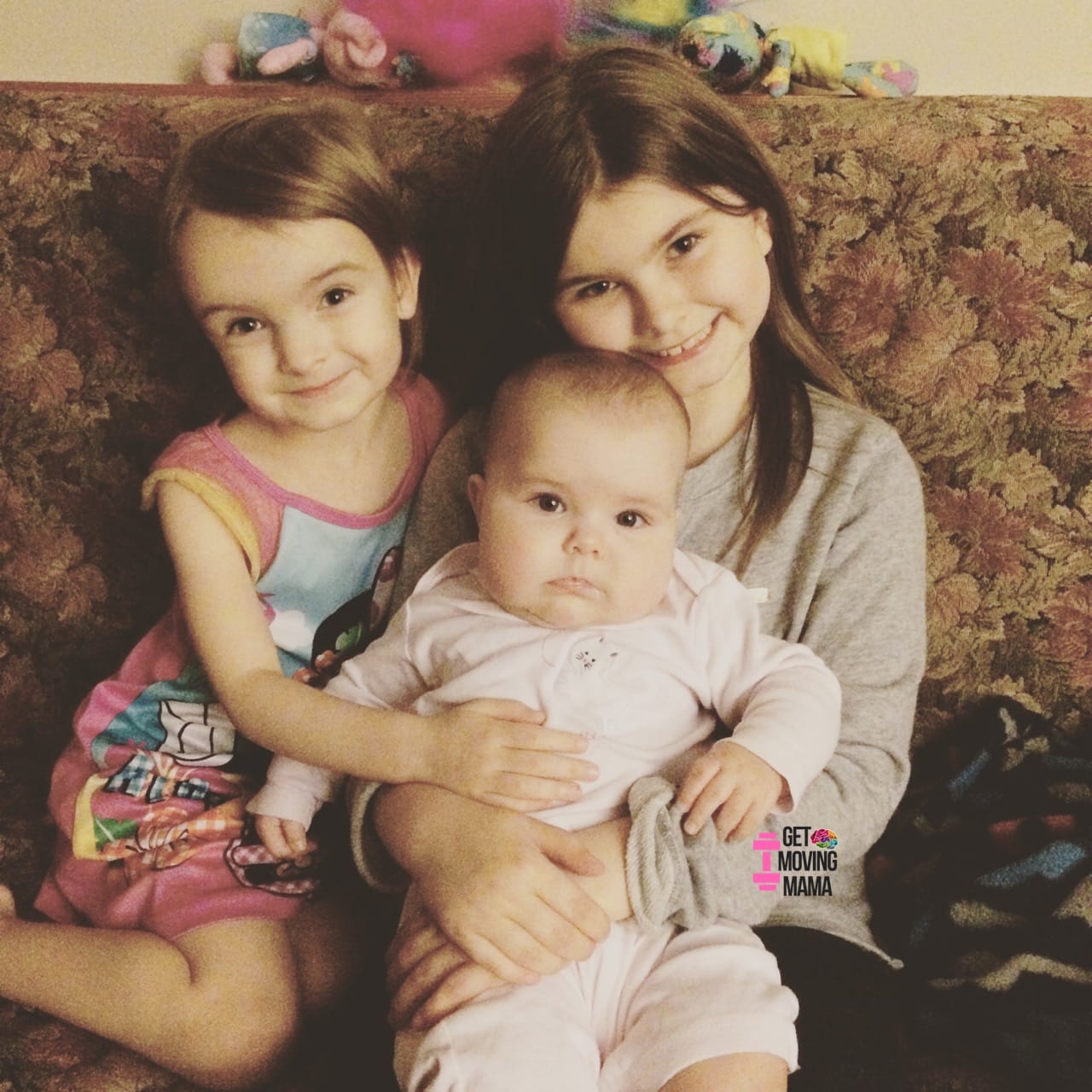 A picture of three girls sitting on a couch together.