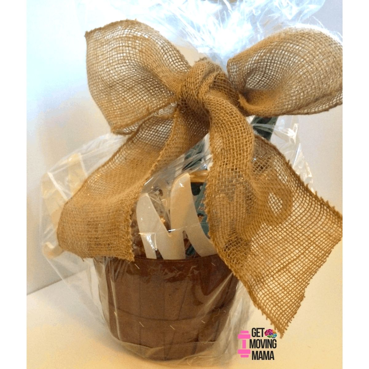 A picture of a wine gift basket with a burlap bow on it.