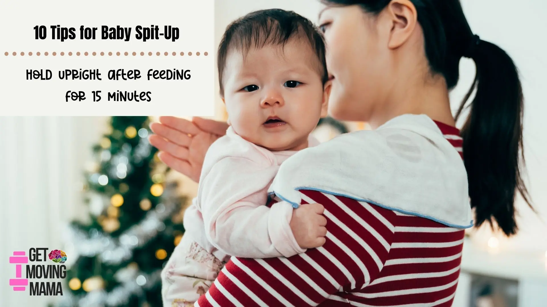 A picture of a mom burping a baby on her shoulder with a Christmas tree in the background.