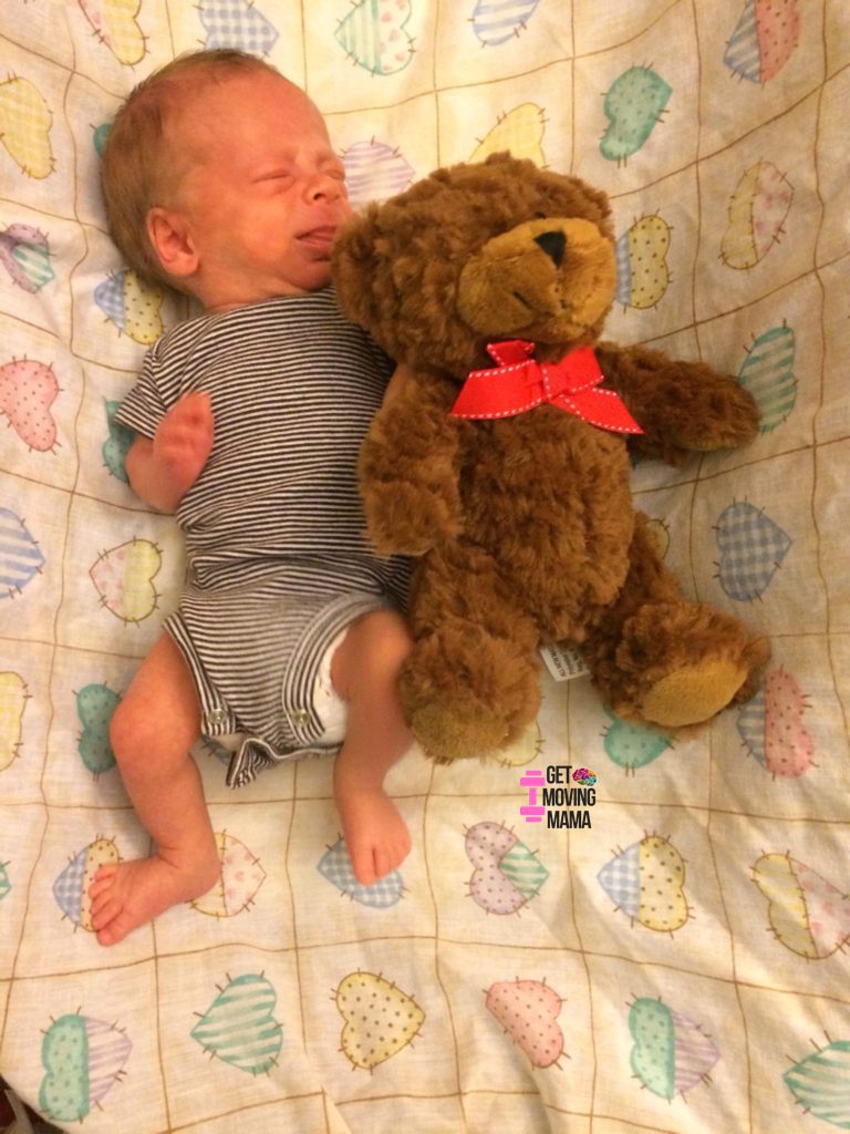 A picture of a preemie baby measured against a teddy bear.